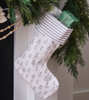 Nikolausstiefel mit grauen Tannenbaum-Mustern neben einer Tannengirlande